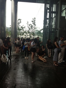 people patiently waiting to catch any glimpse of a kpop idol outside the SBS building